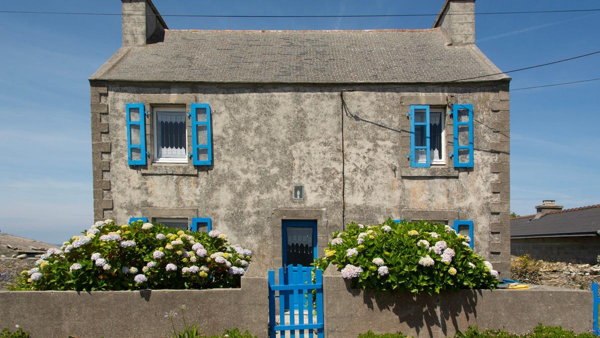 Maison en pierre à volets bleus sous un toit d'ardoise, Ouessant, même ardoise que sur les toits de Morlaix